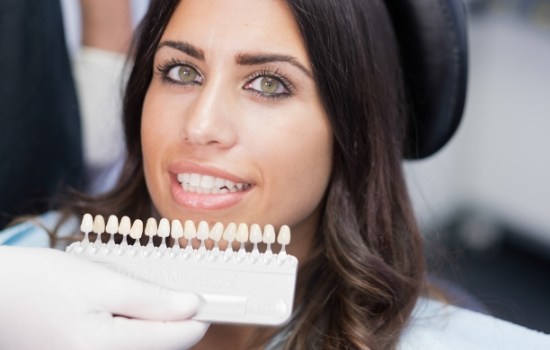 Woman trying on veneers with her cosmetic dentist