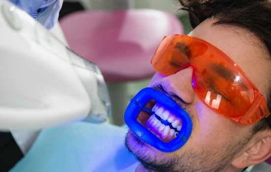 Man getting professional teeth whitening from cosmetic dentist