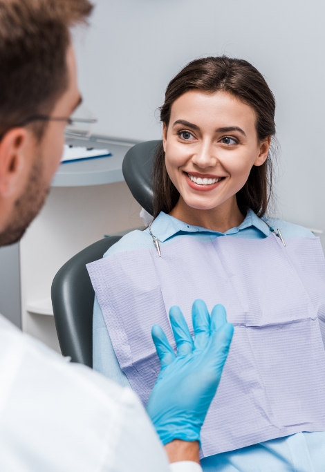 Young woman smiling while talking to her Shelburne dentist