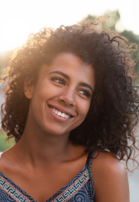 Young woman smiling outdoors after preventive dentistry in Shelburne