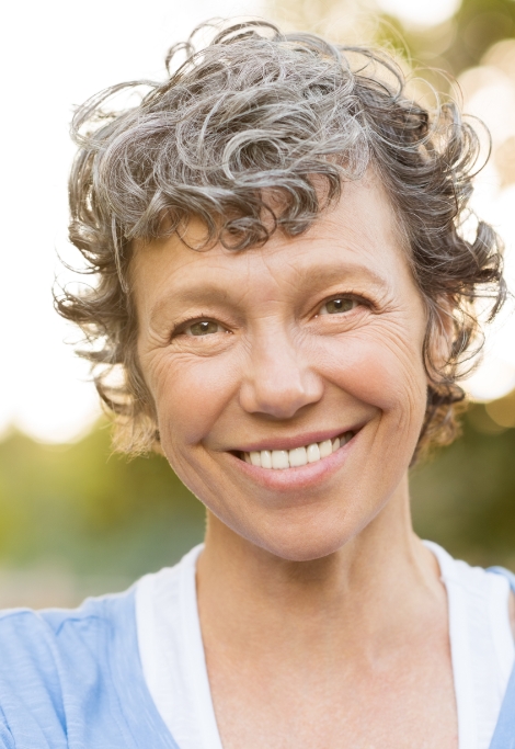 Woman smiling outdoors after T M J treatment in Shelburne