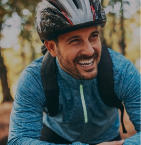 Smiling man on bicycle wearing helmet