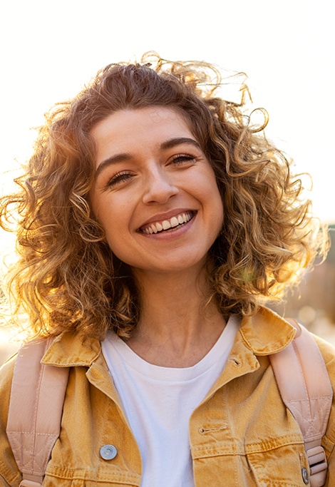 Happy, smiling woman standing outdoors