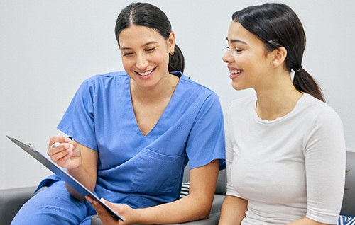 Dental team member and patient discussing treatment directions