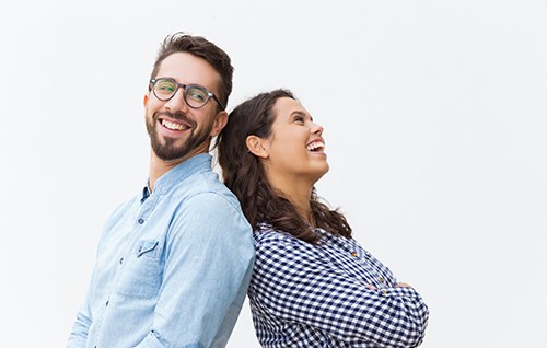 Happy man and woman standing back to back against white background