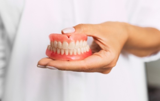 Dentist holding a set of full dentures