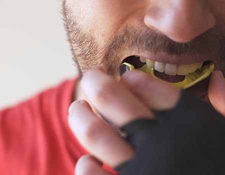 Patient in Shelburne wearing a mouthguard to avoid dental emergencies