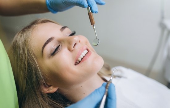 Young woman smiling during dental checkup and teeth cleaning