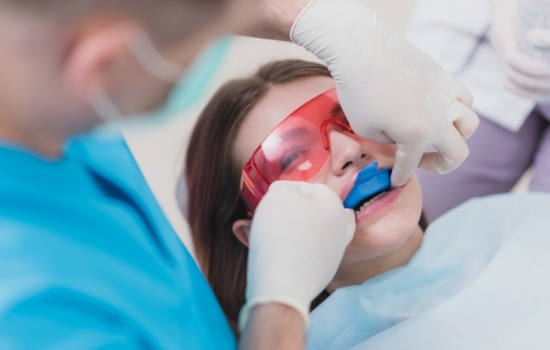 Girl receiving a fluoride treatment in dental chair