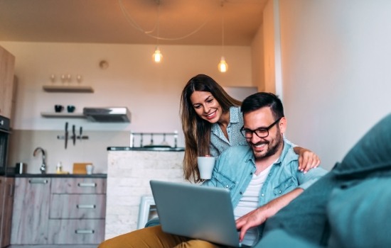 Man and woman on couch looking at laptop