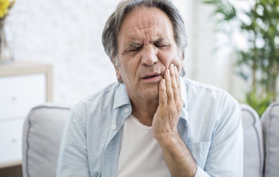 Senior man holding the side of his jaw in pain