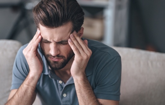 Man holding his temples in pain