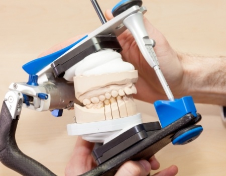 Dentist holding a device to adjust a model of the teeth